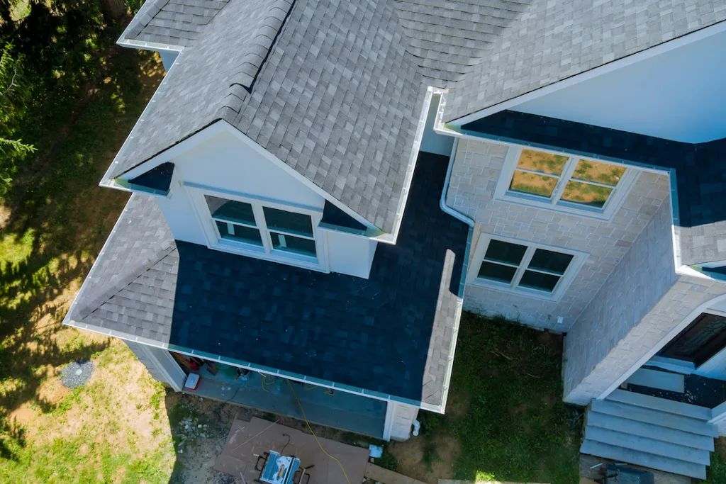 Rooftop in a new home constructed showing asphalt shingles multiple roof lines with aerial view