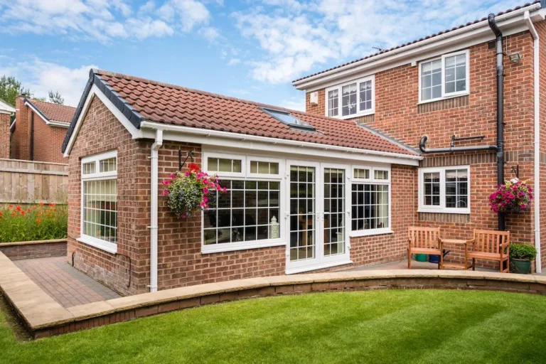 Modern Sunroom external / Modern Sunroom or conservatory extending into the garden, surrounded by a block paved patio